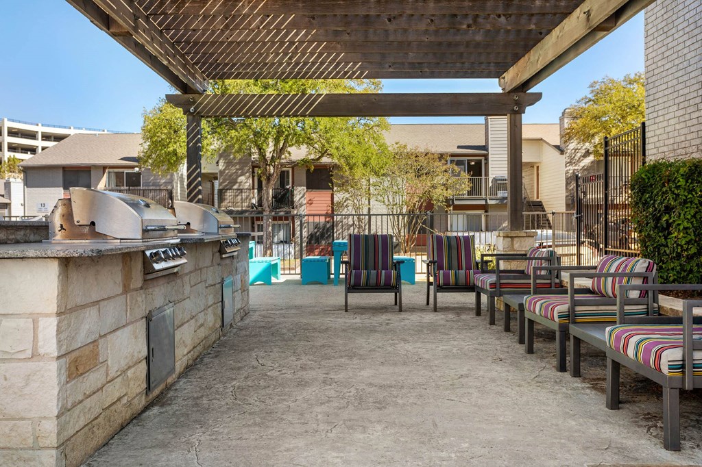 a outdoor patio with a grill and chairs a outdoor patio with a grill and chairs at South Lamar Village, Austin, TX
